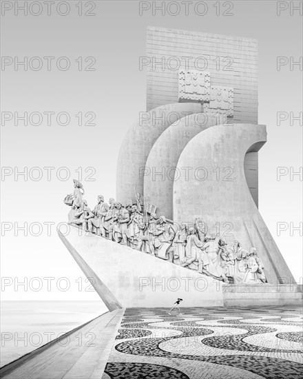 Black and white photograph of a running girl at the seafarers' monument Padrao dos Descobrimentos on the river Tagus in Lisbon