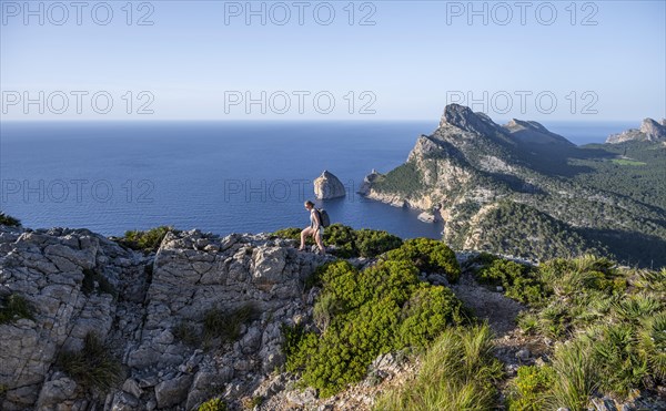 Hiker looking over rocky cliffs and sea