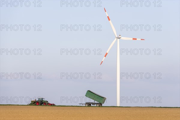 Tractor with trailer sowing grain in a field