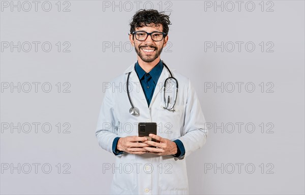 Happy doctor with phone on isolated background. Smiling doctor using cellphone isolated
