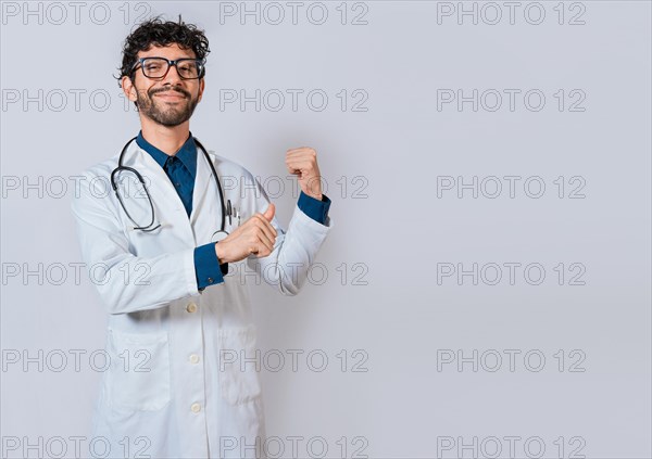 Smiling doctor pointing back isolated. Doctor pointing back with his thumbs