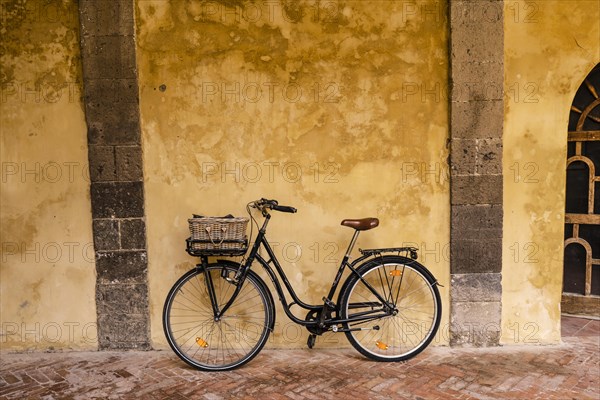 A bicycle leaning against the wall inside Saint Francis cloister in Sorrento