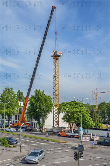 A construction crane is erected with a truck-mounted crane