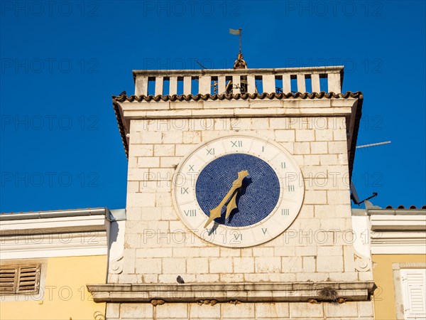 Clock at the sea gate in the evening light