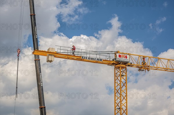 A construction crane is erected with a truck-mounted crane