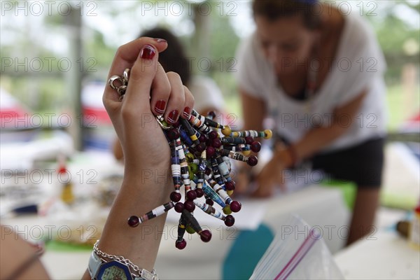 Womens hand with key rings made from old newspapers