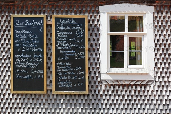 Menu and drinks menu on a slate board on an old house