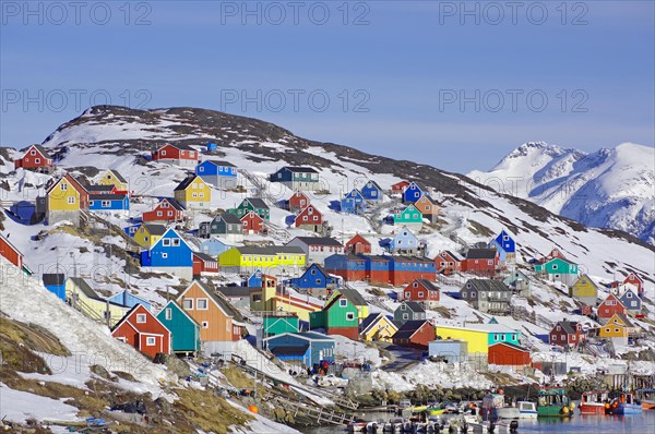 Wooden houses in different colours in winter landscape