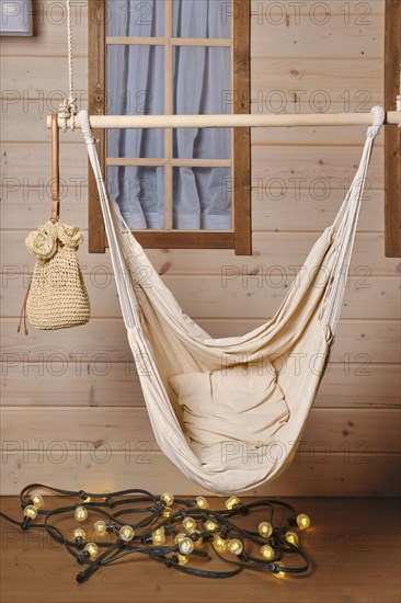 Empty hammock on the terrace of wooden cabin