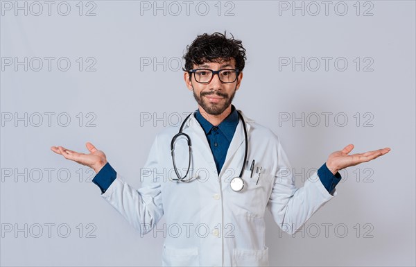 Doctor presenting something with both palms. Young doctor with palms open to the sides. Bearded doctor with both palms open