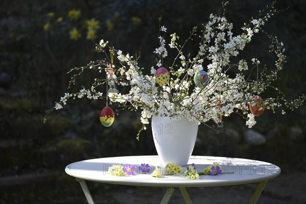 Easter bouquet with hand-painted Easter eggs in a vase in the garden