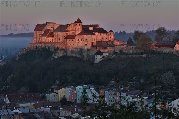 The castle in Burghausen in the first light of the morning above the historic old town