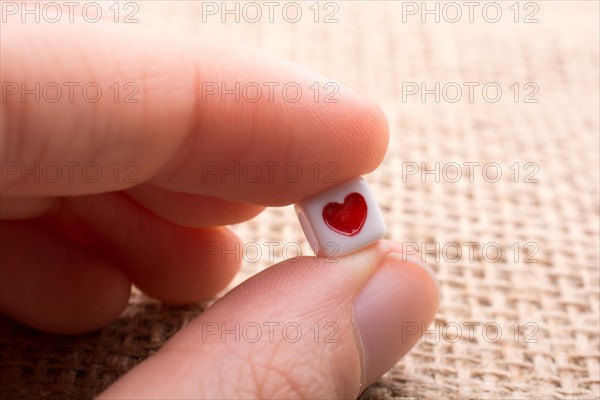 Colorful cube with a heart in hand on canvas