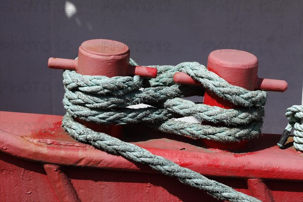 Red ship's bollard wrapped with ship's rope