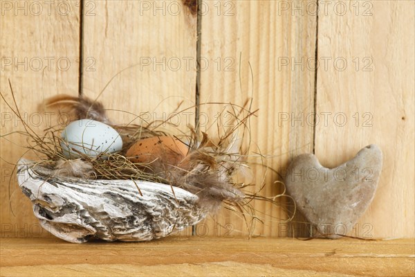 Easter nest in a shell with Easter eggs and a stone heart