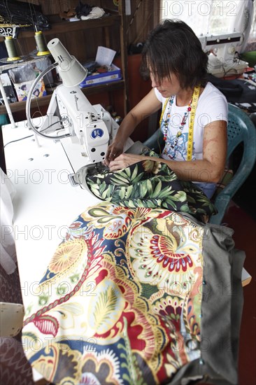 Costa Rican woman sews a bag from recycled fabric