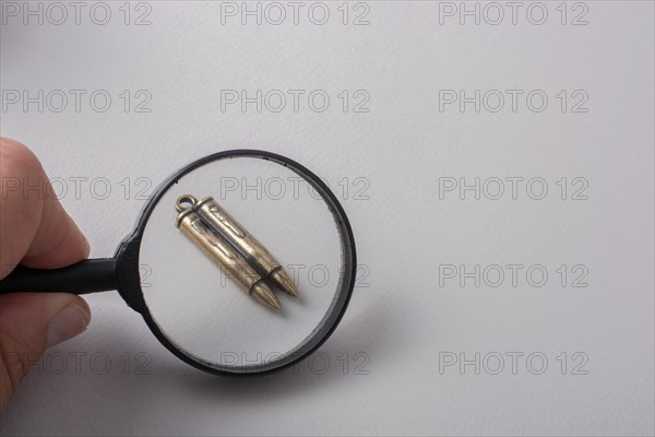 Bullet under magnifying glass as Conceptual against the war photography