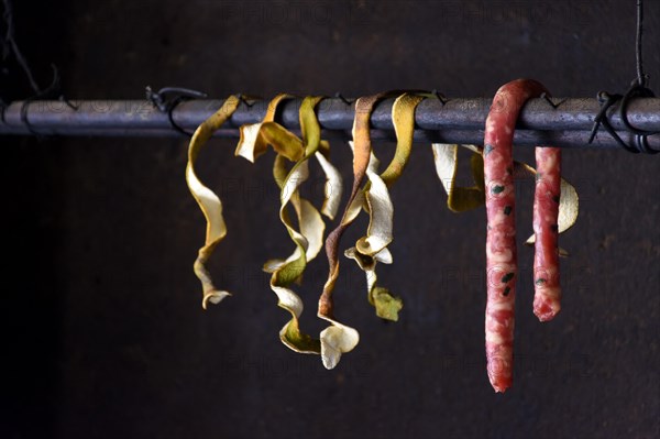 Raw sausage and orange coats hanging in the interior of popular cuisine in Brazil