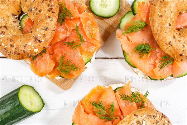 Bagel sandwich for breakfast topped with salmon fish from above on a wooden board in Stuttgart