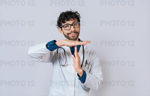 Male doctor gesturing time out. Doctor making time out gesture with palms on isolated background