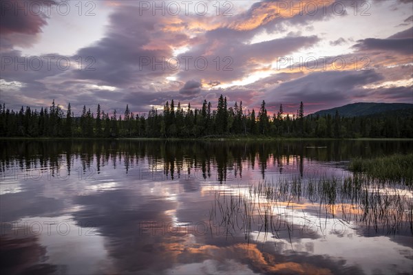 Dramatic sunset by the river Namsen with reflection