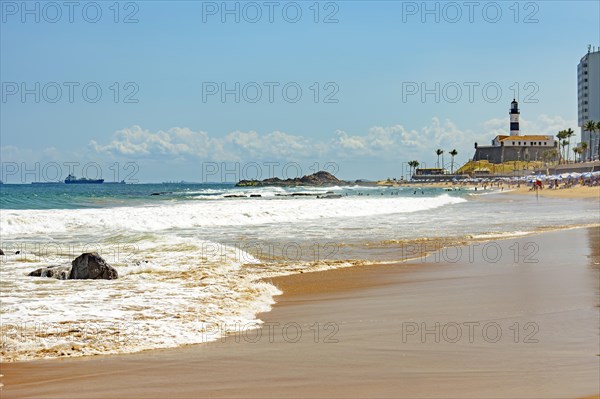 Barra beach buildings and lighthouse seen from afar with the summer sun of Salvador in Bahia