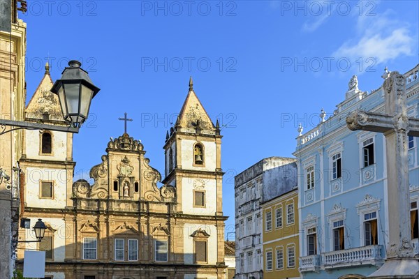 Facade of an old historic church and colorful colonial-style houses in the central square of the Pelourinho district in Salvador city