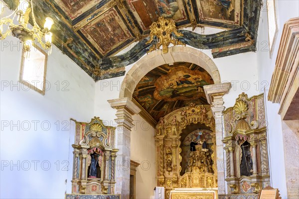 Interior and altar of a brazilian historic ancient church from the 18th century in baroque architecture with details of the walls in gold leaf in the city of Tiradentes