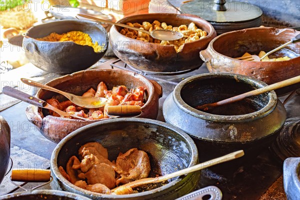 Traditional Brazilian food being prepared in clay pots and in the old and popular wood stove