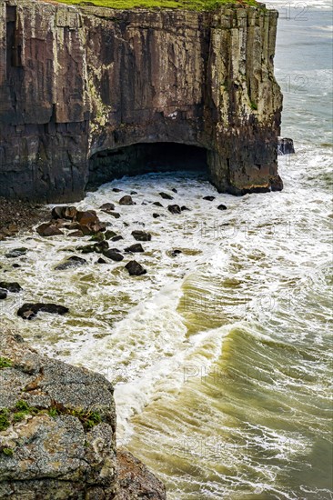 Waves crashing against a cliff and a cave on the coast of the city of Torres in Rio Grande do Sul