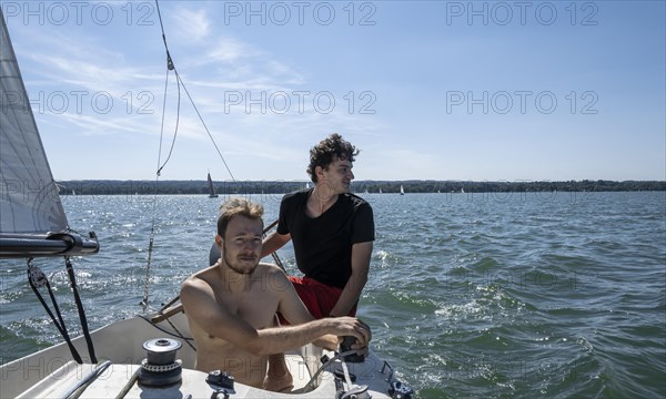 Two young men sailing on a sailboat