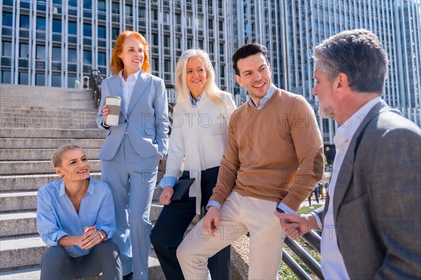 Talking before going to work. Group of coworkers outdoors in a corporate office area