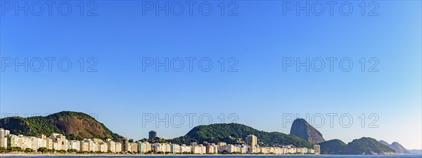 Panoramic image of Copacabana Beach and Sugar Loaf Mountain with its buildings and hills seen with the sea