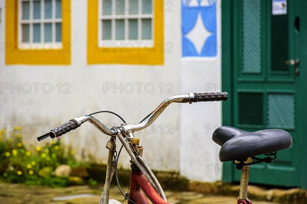 Old bicycle stopped in front of the colonial style houses of the historic city of Paraty on the south coast of Rio de Janeiro