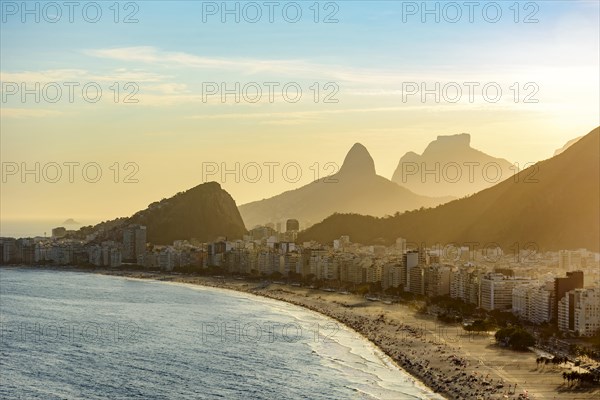 Golden sunset between Copacabana buildings and hills