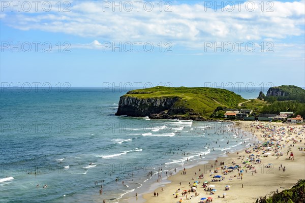 Crowded beach on a beautiful sunny day in the summer of Torres city on the coast of Rio Grande do Sul state