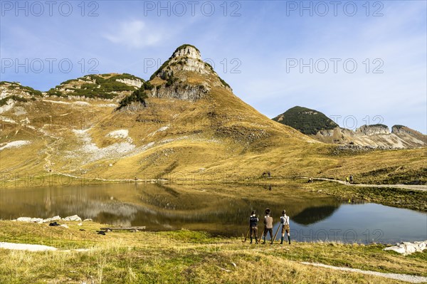 The Austrian alphorn trio Klangholz plays the alphorn at the Augstsee on Mount Loser