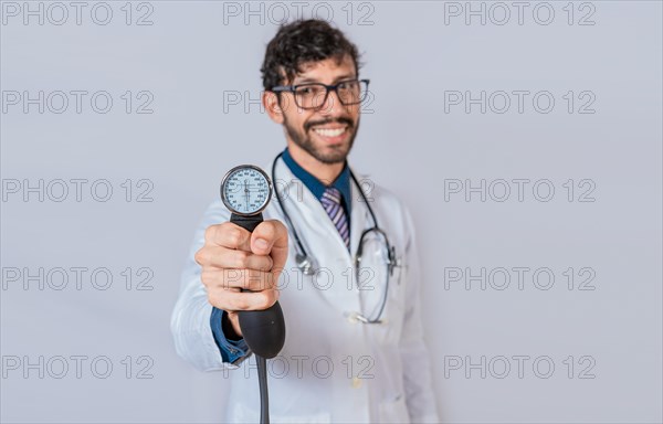 Handsome doctor showing blood pressure monitor isolated. Smiling doctor holding blood pressure monitor