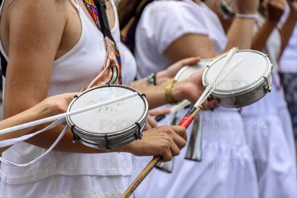 Women playing tambourine in the streets of Brazil during a samba performance at street carnival in Brazilian cities