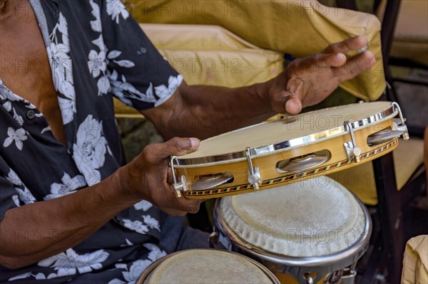 Detail of musician playing tambourine in the streets of Pelourinho in Salvador in Bahia during a samba performance at Carnival