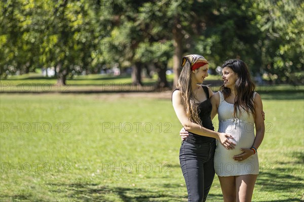 Happy pregnant lesbian couple at outdoors. LGBT