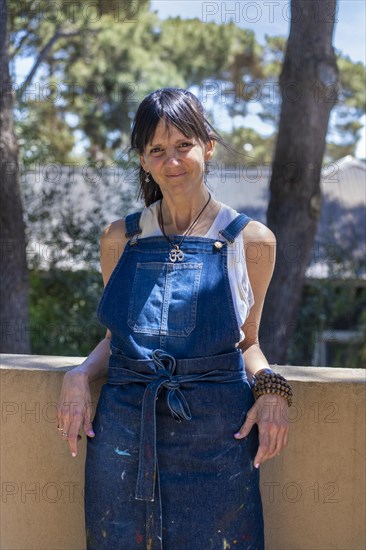 Portrait of a smiling woman artist looking at camera