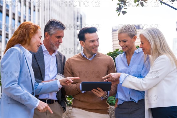 Cheerful Portrait of a happy group of co-workers laughing and having fun outdoors a corporate office area. High quality photo