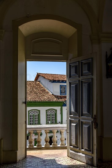 Antique colonial houses seen through the door of historic church in the city of Diamantina in Minas Gerais