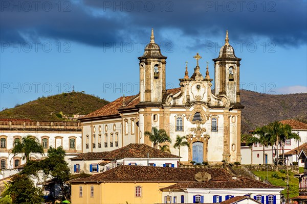 Old churches on top of the hill and between the houses in the city of Ouro Preto in Minas Gerais during the late afternoon