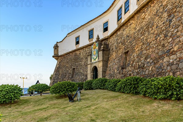 Facade of the old and historic fort and Barra lighthouse at afternoon in the city of Salvador