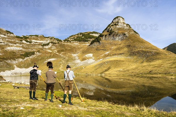 The Austrian alphorn trio Klangholz plays the alphorn at the Augstsee on Mount Loser