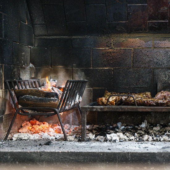 Flames of fire and roasted meat. Argentinian barbecue
