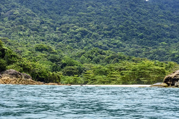 Paradise deserted beach hidden between the rainforest and the rocks in Trindade