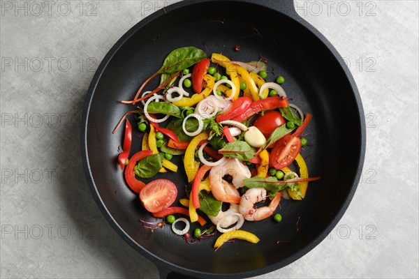 Top view of fresh vegetables and shrimps in a frying pan